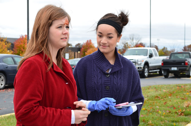 Junior Renata Williams, who plays a crime scene investigator, stands with senior Wynter Bresaw, who is in the role Betty Quick, a suspect in the investigation of this accident. Photo by Brittany Corneilson