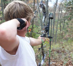 Aim and fire: Senior Sam Chapin practices using his bow and arrow. He enjoys shooting recurve, compound and crossbows to give him more of a challenge while hunting deer. 