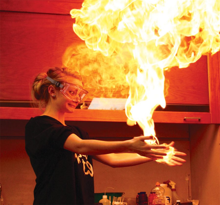 Superpowers activate: Senior Kenzie Jacoby holds fire as part of an honors chemistry combustion reaction experiment. District officials scrapped the lab for 2012 due to liability issues. This photo was retrieved with permission from Flashback 2011.