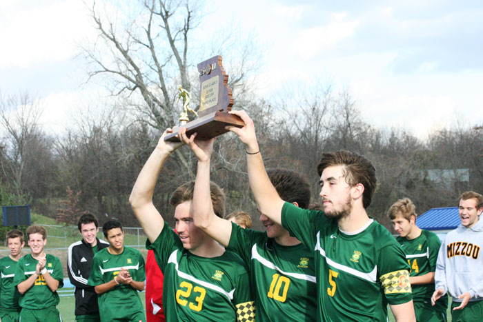 The rest of the soccer team celebrates and commemorates the seniors as team captains senior Matt Kelly (left), Kory McDonald (middle) and Sam Stoeckl (right) hoist the third place trophy high in the air. Photo by Parker Sutherland
