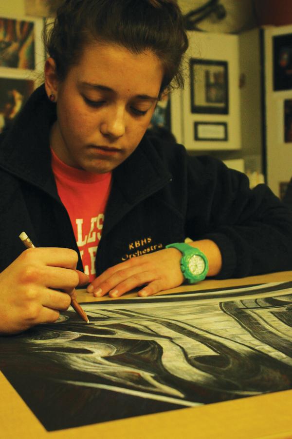 Drawing the day away: During her lunch, senior Cora Trout finishes her most recent piece of work inspired by architectural columns. Trout has taken art classes by choice for five years now. Although she is not planning to pursue a career in art, she hopes to continue drawing as a hobby and as means of expression. Photo by Halley Hollis