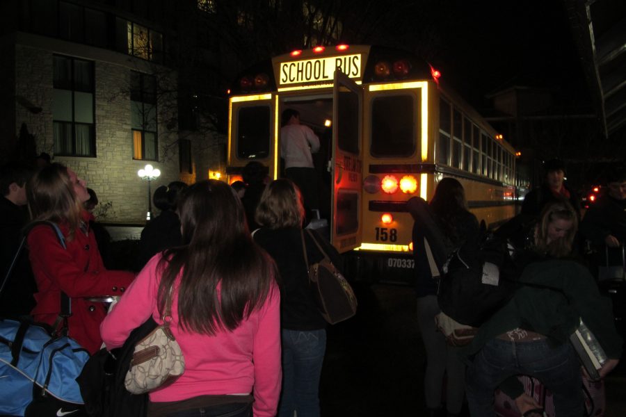 Students unload suitcases, snacks and instruments from the back of the bus Wednesday night. 