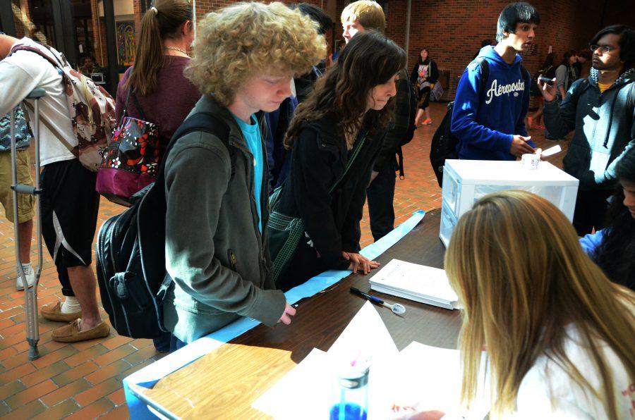 Standing at the booth, juniors Randy Hildebrand and Elena Tucker vote for their favorite candidate in the mock election. The booth was set up to get more people involved in political events.  