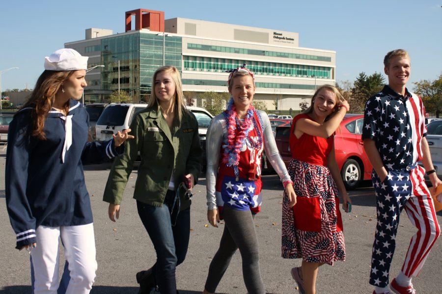 Homecoming candidates Morgan Widhalm (far left), Sydney Strong (left center), Taylor Wilson (center), Annie Rumpf (center right), and homecoming escort Alex Jones (far right) head into the Veterans Hospital, bringing their vibrant colors and patriotism with them.