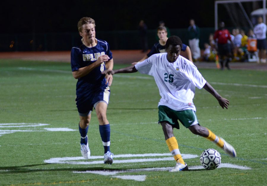 Freshman Tarnue Tyler dribbles the ball down the field in the game against Helias Oct. 1. 