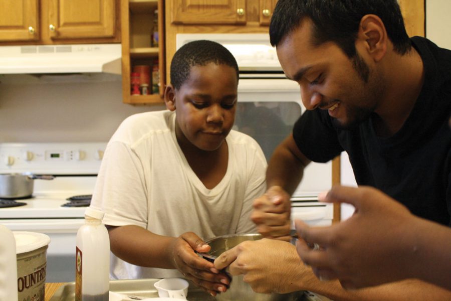 Cookies for cash:  Senior Rasheeq Nizam bakes cookies with a Russell Elementary student at the Intersection in preparation for today’s bake sale to sponsor RBHS teams for a dodgeball fundraiser next month. RBRO volunteers at the Intersection Monday through Friday. Photo by Aniqa Rahman
