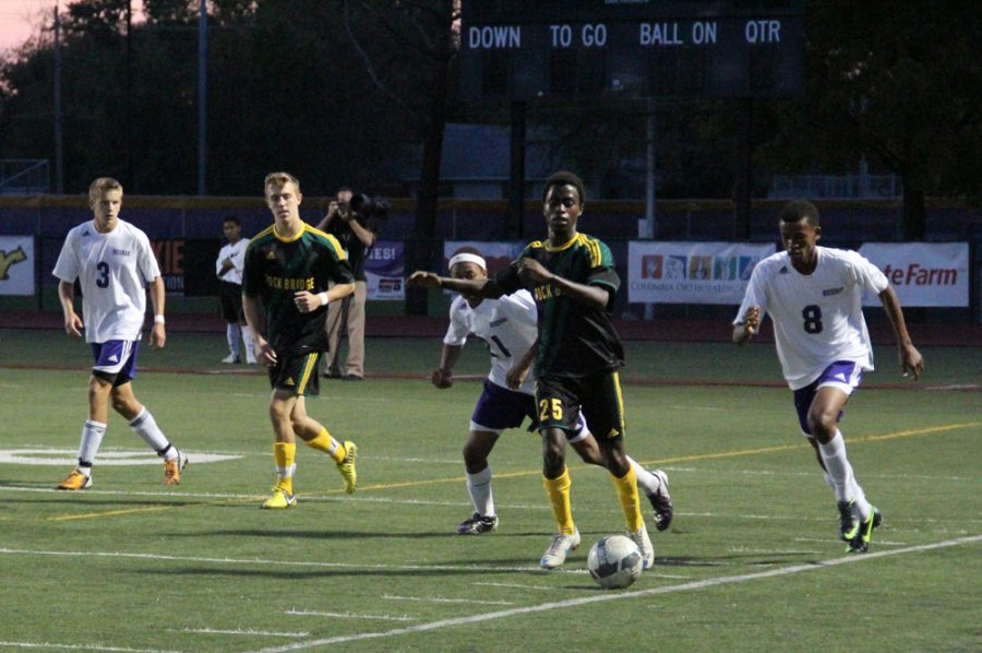 Freshman Tarnue Tyler dribbles the ball up the field Sept. 26 at the Hickman v. Rock Bridge game as Hickman players Sophomore Marcus Tigue (middle left) and senior Philos Twagirayezu (right) run after the Bruin striker and wing midfielder. Photo by Daphne Yu