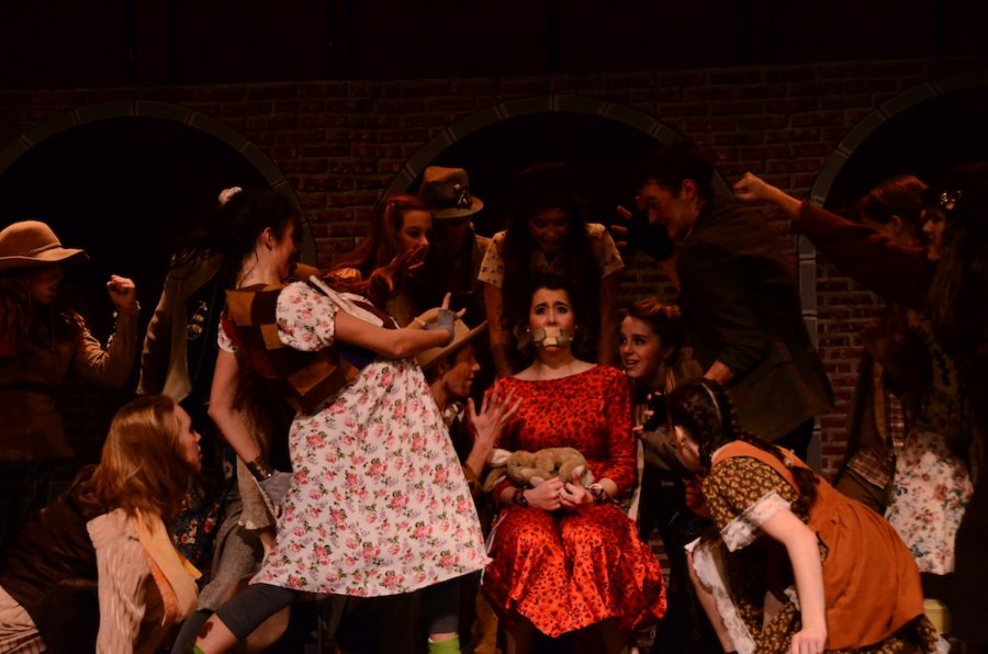 Megan Kelly as Hope Cladwell, surrounded by the Poor Chorus during the song  Snuff That Girl in Urinetown: The Musical. Junior Megan Kelly, who plays Hope Gladwell, falls in love with Bobby Stong, played by senior Ian Meyer, not pictured. Photo by Laurel Critchfield