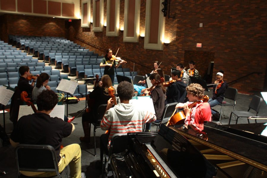 The orchestra tunes their instruments as they begin their last rehearsal before a concert. Photo by Lauren Puckett