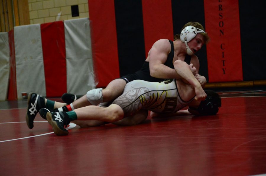 junior Sam Crane tries to flip his Kickapoo opponent onto his back in the district tournament at Jefferson City High School. Crane finished state runner-up in the 138 weight class. photo by Rachel Kiehne