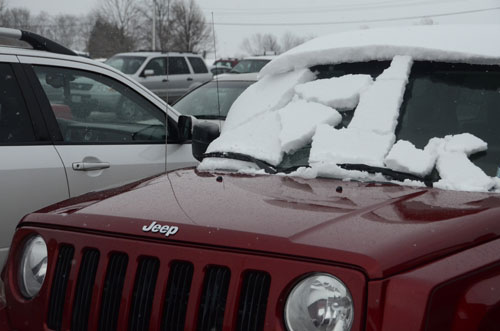 Snow chunks fall off the windshield of a vehicle in the RBHS parking lot, Feb. 25.