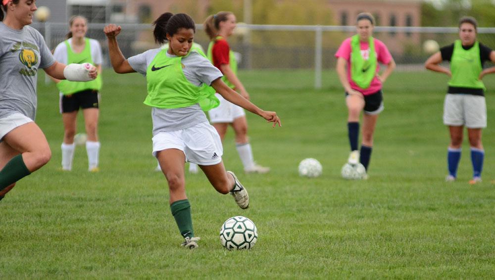 Senior Olivia Mends strikes the ball during a scrimmage in preparation for the district tournament. Mends played mid-fielder and forward for the varsity girls soccer team this season. Photo by Aniqa Rahman