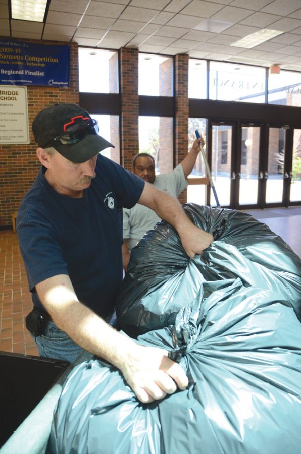 Taking out the trash: Janitor Greg Reinkemeyer places trash bags in the easy to move bin at the main entrance after lunch.  Reinkemeyer is part of the  tenacious RBHS custodial staff.
photo by Urmilla Kutikkad