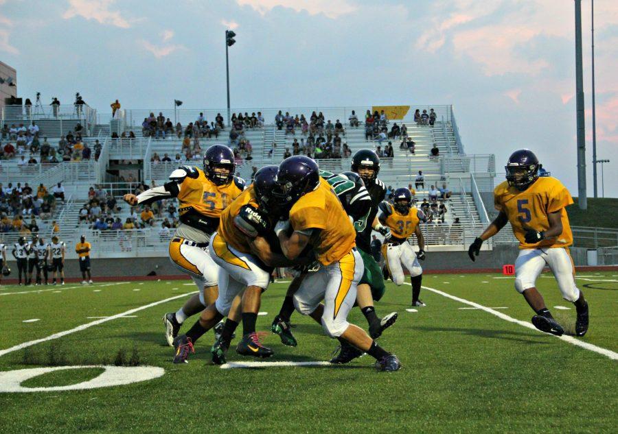 Three Kewpies against one Bruin, fighting to either end rushing yards or pushing towards a touchdown.
Photo by Morgan Berk.
