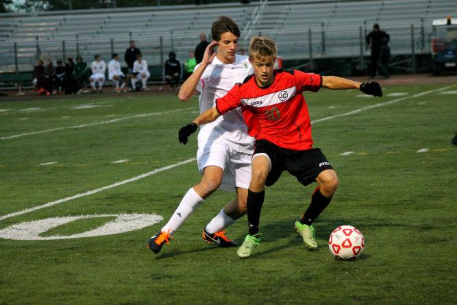 Connor Blitz, grade 11, defends the opposing team member from turning the ball around and heading for the goal.