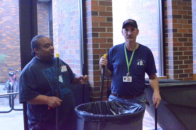 Custodians Frederick Robinson (right) and Greg Reinkenmeyer (left) clean up trash left behind during students after lunch. Reinkenmeyer said it is important for students to do their part in keeping the building clean and garbage-free.