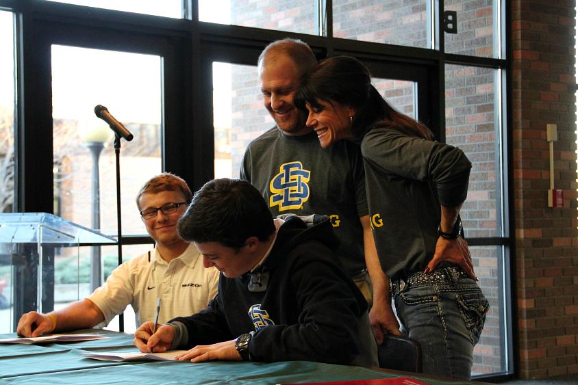 Senior+Quinn+Smith+signs+his+letter+of+intent+for+wrestling+at+South+Dakota+State+University%2C+accompanied+by+his+parents.