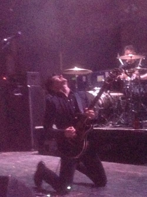 Arctic Monkeys lead singer drops to his knees during a guitar break