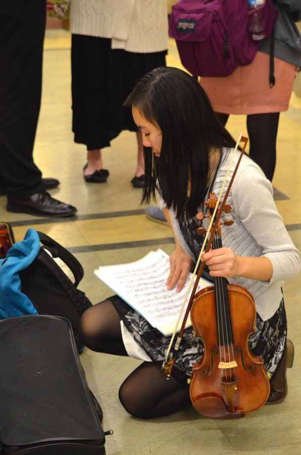 Hannah Chen gathering her sheets of music before performing her sting duet with Amy Gu 