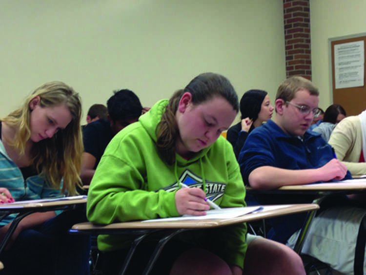 Test Takers: From left, senior Audrey Clark, junior Mallory Bolerjack and junior Robert Schimdt take the two-and-a-half hour AP Pyschology final in May. Photo by Alice Yu 