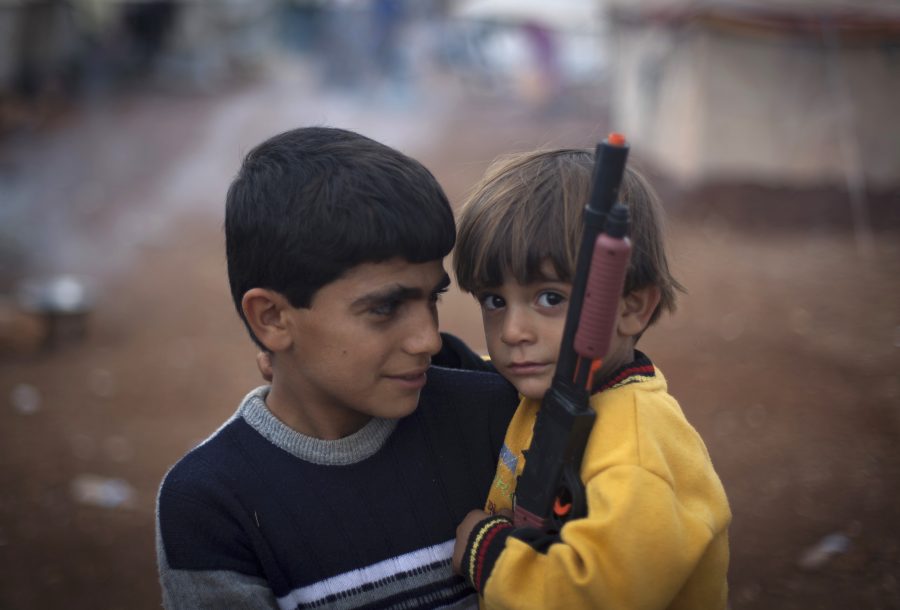 Two+Syrian+boys+who+fled+with+their+families+from+the+violence+in+their+village%2C+look+on+as+one+holds+a+gun+toy+at+a+displaced+camp%2C+in+the+Syrian+village+of+Atmeh%2C+near+the+Turkish+border+with+Syria%2C+Thursday%2C+Nov.+8%2C+2012.%28AP+Photo%2F+Khalil+Hamra%29