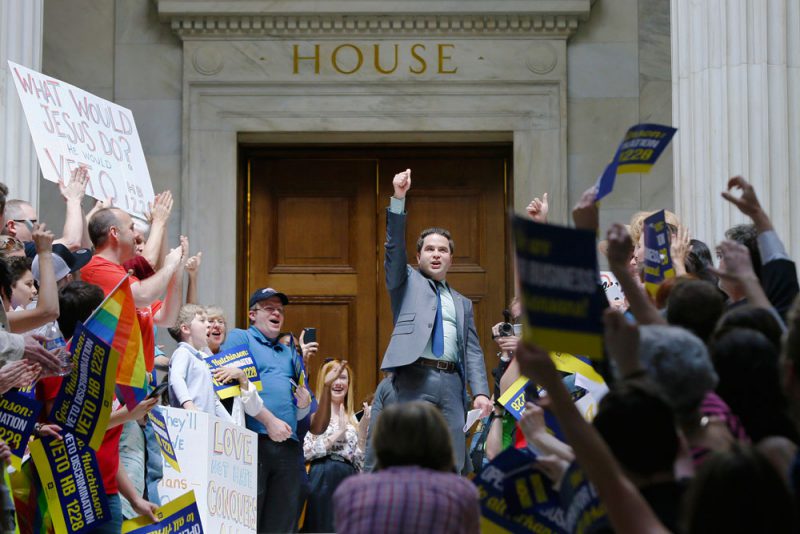 In this March 30, 2015 file photo, Rep. Warwick Sabin, center, D-Little Rock, cheers with others protesting over new religious objections laws at the state Capitol in Little Rock, Ark. The national focus on whether new religious objections laws in Indiana and Arkansas could be used to discriminate against gays and lesbians has boosted efforts for broader civil rights law protections in those and other states. (AP Photo/Danny Johnston, File)