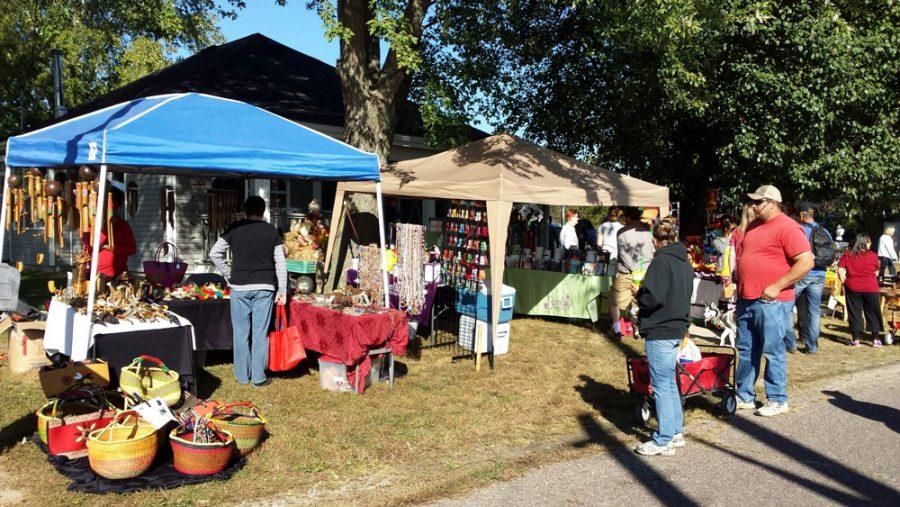 Festival goers gather around a craft booth at the Hartsburg Pumpkin Festival