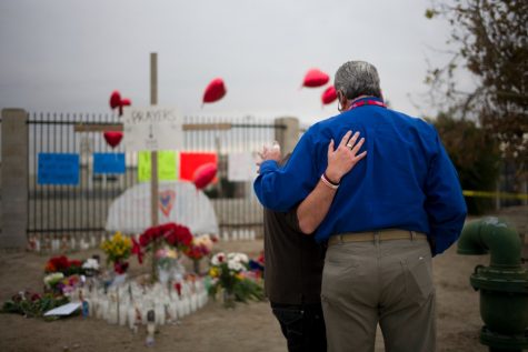 Chaplain Chuck Bender, right, prays with Michael Davila at a makeshift memorial honoring the victims of Wednesdays shooting rampage, Friday, Dec. 4, 2015, in San Bernardino, Calif. The FBI said Friday it is officially investigating the mass shooting in California as an act of terrorism, while a U.S. law enforcement official said the woman who carried out the attack with her husband had pledged allegiance to the Islamic State group and its leader on Facebook. (AP Photo/Jae C. Hong)