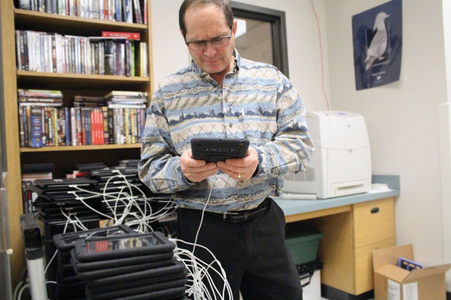 RBHS media specialist, Dennis Murphy, looks at an iPad while it charges. Murphy often reminds students that food and drinks are not allowed, and prohibits computer games played by students. This situation, however, involved much more than innocent computer games.