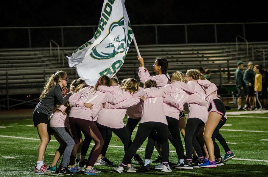 The senior team in 2016s powderpuff match makes an entrance much like that of the RBHS football team by running in with the RBHS flag and getting into a huddle before their game against the sophomores. Photo by Yousuf El-Jayyousi