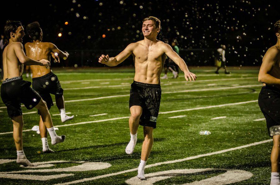 Right as rain: Soaking himself with water, senior Isaac Lage and the Bruin Boys celebrated on the field before the last game of powder puff to entertain the crowd. Lage and other Bruin Boys also served as coaches for the girls’ football teams. Photo by Yousuf El-Jayyousi