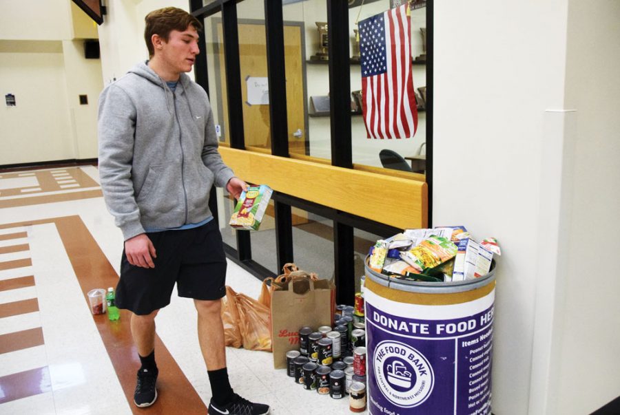 Senior Isaac Lage donates to the National Honors Society food drive. Photo by Cassidy Viox