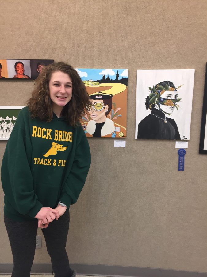 Sophomore Mariah Blackburn stands next to art pieces at the 12th Annual High School Art Competition and Exhibition, hosted by Columbia College. Blackburn was one of a group of RBHS students who earned prizes for their pieces, taking home first in Paintings. 