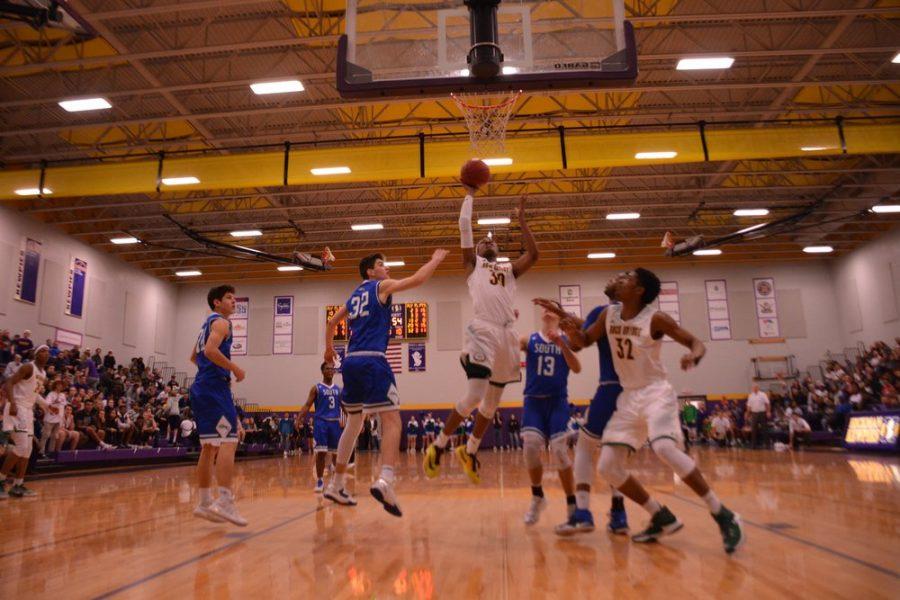 Sophomore Isiaih Mosley shoots a layup to tie the Jaguars of Blue Springs South at 56 a piece. Rock Bridge would go on to win the game on a free throw 57-56 in the final seconds of the game. RBHS Advances to the next round of districts, and will play the winner of Blue Springs and Hickman. Photo by Tyson Jamieson.