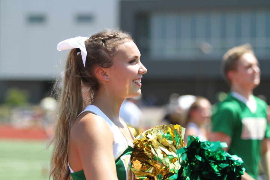 Senior Elizabeth Curtwright smiles from the sideline as she cheers on RBHS football at the game against BHS on Sept. 1. Photo by Camryn Devore