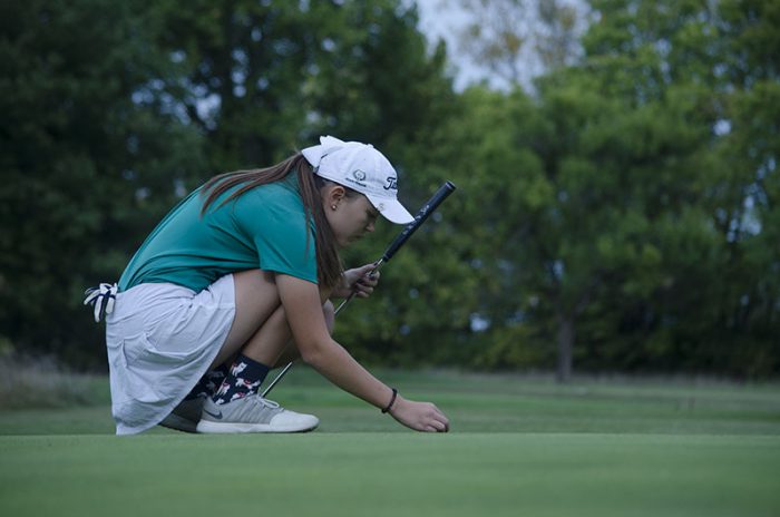 Sophomore Caroline Schade bends to tee her ball at the Oct. 10 Class 2 Girls Golf state championship.