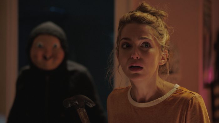 Tree (Jessica Rothe) stars in Happy Death Day. Rothe in suspense scene with killer stalking her from behind. Used with permission from happydeathdaymovie.com