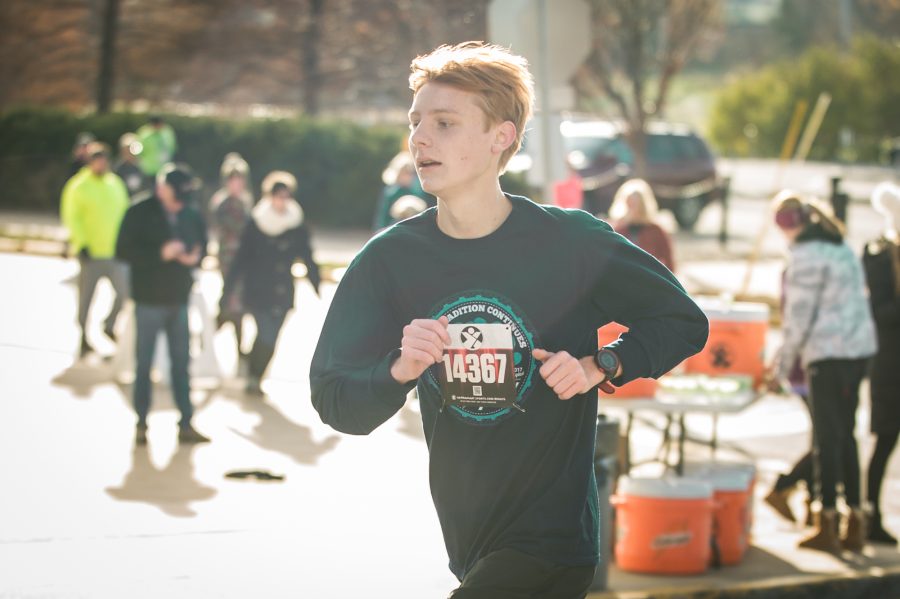Senior Kevin Kiehne passes the aid station approximately two and half miles into the Turkey Trax Run on Nov. 23. Kiehne finished tenth overall out of the 1,282 participants this year. Photo by Yousuf El-Jayyousi
