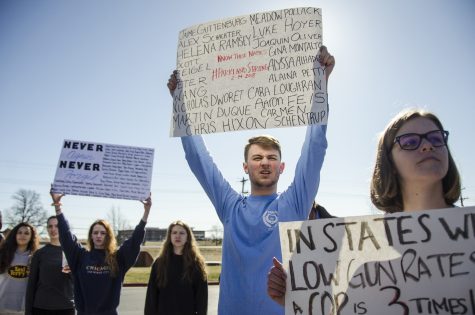 Junior George Frey holds a sign with the names of the Parkland, Fla. shooting victims. On Feb. 14, 14 teenagers and 3 adults were killed by a man armed with an AR-15. Photo by Maya Bell.