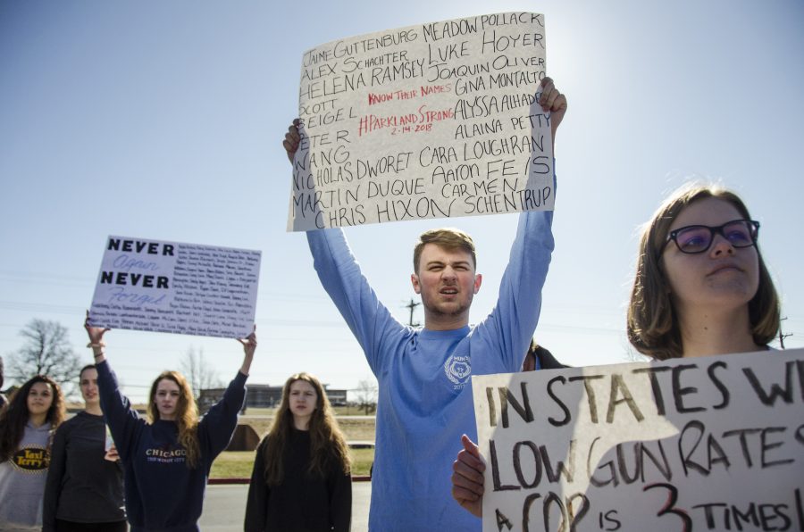 Junior George Frey holds a sign with the names of the Parkland, Fla. shooting victims. On Feb. 14, 14 teenagers and 3 adults were killed by a man armed with an AR-15. Photo by Maya Bell.