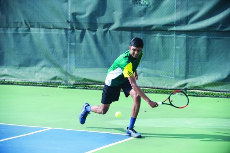 Junior Kavin Anand prepares to hit the ball with a back hand on April 26 against the Kewpies (9-0). The Bruins compete in individual districts May 12.