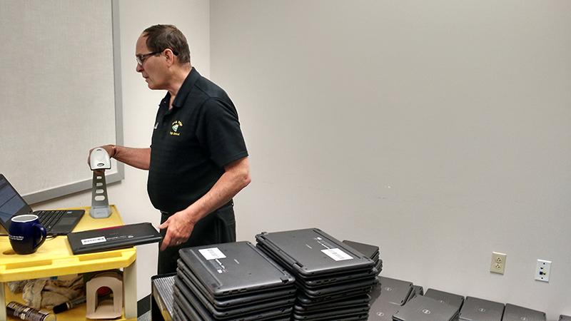 Dennis Murphy checks in all the laptops that have been turned in so far. Photo by Isaac Parrish.
