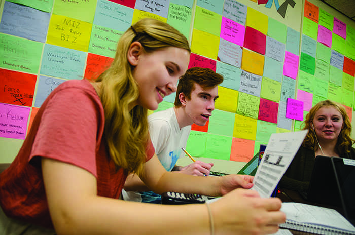 Sophomore Sarah Kuhlman looks at her Interim Progress Report (IPR) while juniors Carter Foust and Dani Barnes anticipate their own IPRs on April 23. Students received their report cards on a Monday because of a mix-up in putting correct grades.