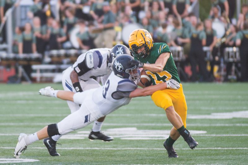 Junior linebacker David Gysber battles the Lees Summit West Titans to keep possession of the ball at the Sept. 14 RBHS home game. Photo by Maya Bell.