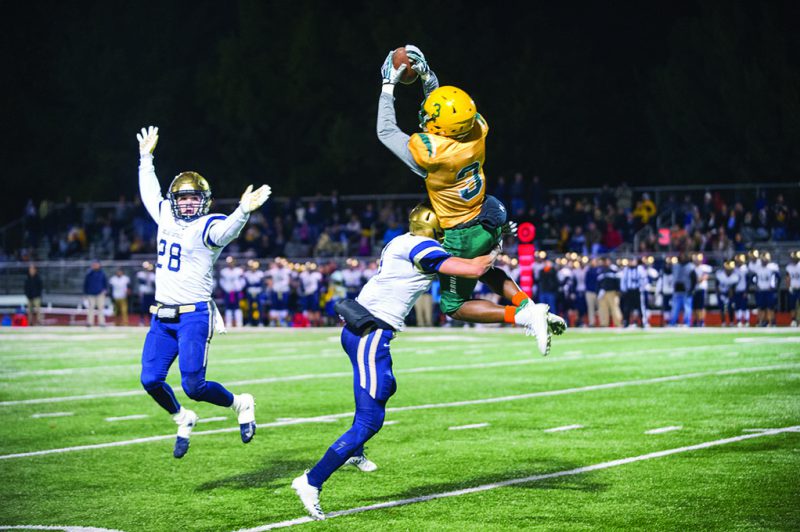 PLUCKED%3A+Senior+wide+receiver+Martez+Manuel+makes+a+flying+catch+as+he+receives+a+pass+from+junior+quarterback+Grant+Hajicek.+The+Bruins+defeated+the+Helias+Crusaders%2C+52-28%2C+Oct.+12.+The+game+marked+both+the+Bruins%E2%80%99+homecoming+and+%E2%80%98orange+out%E2%80%99+game%2C+which+showed+support+for+those+suffering+from+leukemia.+The+Bruins+will+begin+their+district+tournament+tomorrow+night.+Photo+by+Maya+Bell.