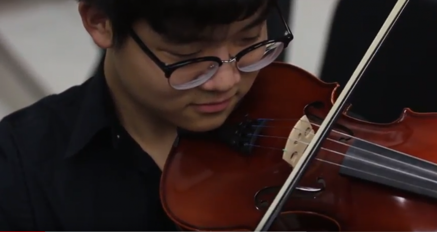 Senior violinist Sejoon Jun warms up before the RB orchestra concert. Photo by Matt Burns.