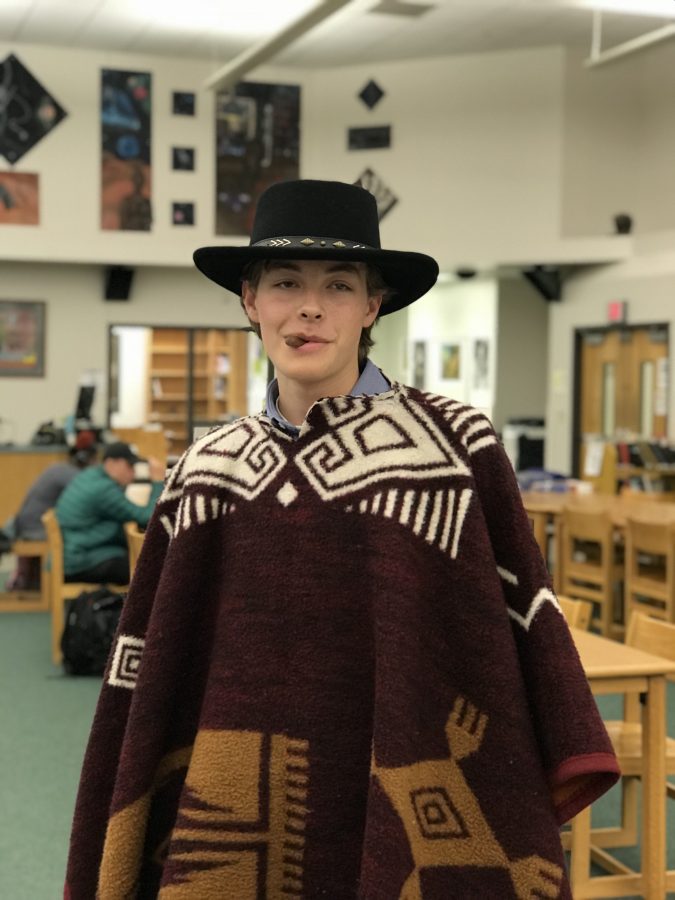 Senior+Lucas+Harper+wears+a+Clint+Eastwood+inspired+look+complete+with+a+poncho+and+fake+cigar%2C+which+he+substituted+for+a+Tootsie+Roll.+Photo+by+George+Frey.