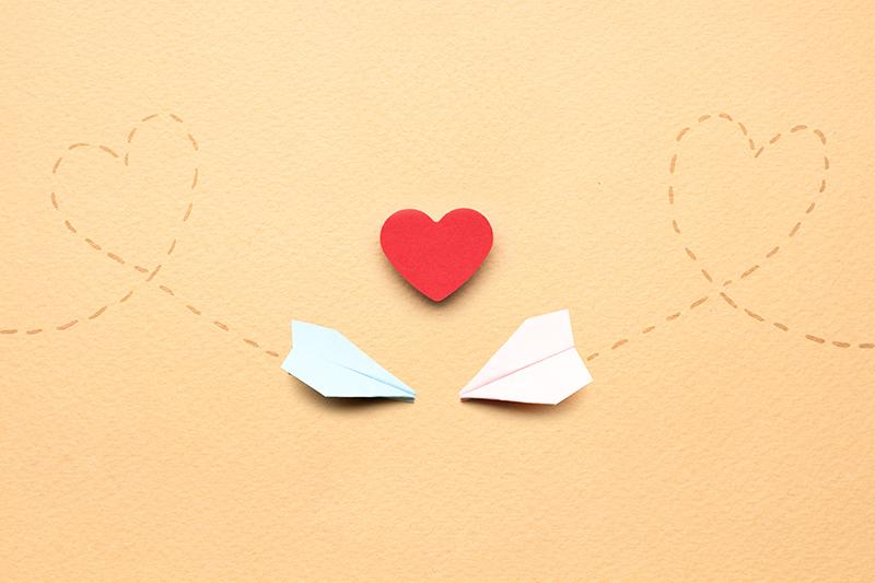 Creative+valentines+concept+photo+of+two+paper+planes+and+a+heart+on+brown+background.