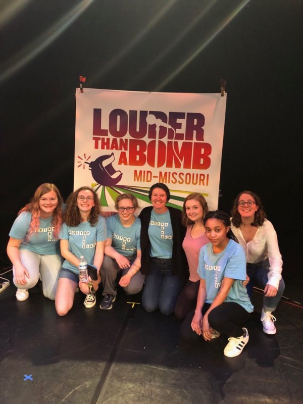 Students and coach Daryl Moss pose at the Warehouse Theater after winning second runner-up a Mid-Missouri Louder Than a Bomb finals.