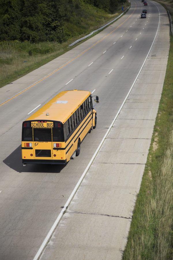 Yellow school bus travels along the road. Photo from envato elements